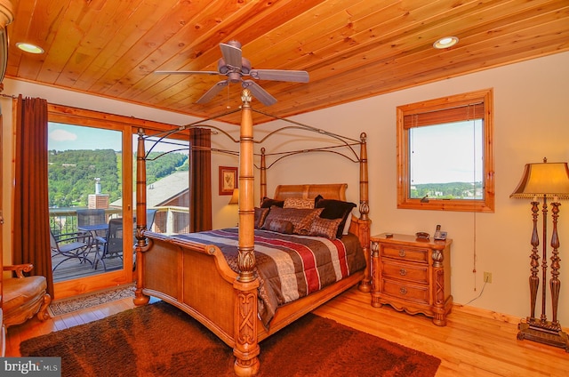 bedroom with light wood-type flooring, access to exterior, and multiple windows