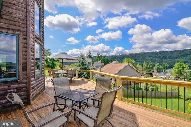 wooden terrace featuring a lawn