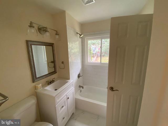 full bathroom with toilet, vanity, and tiled shower / bath