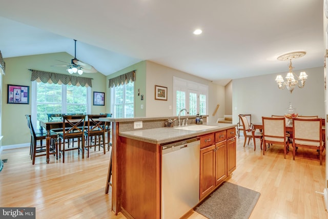 kitchen featuring ceiling fan with notable chandelier, a kitchen island with sink, dishwasher, and plenty of natural light