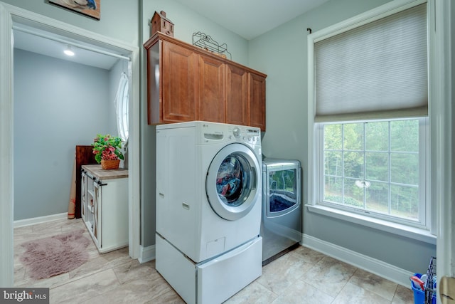 washroom featuring cabinets, light tile patterned floors, and separate washer and dryer