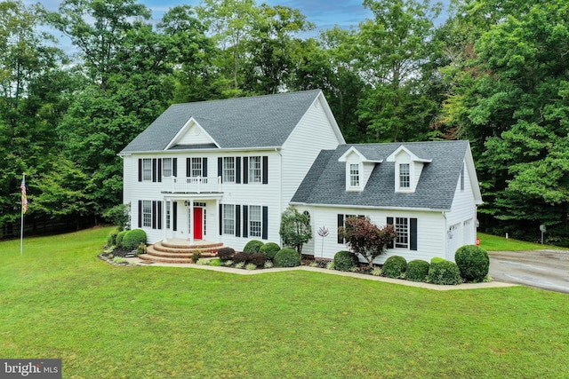 colonial house featuring a garage and a front lawn