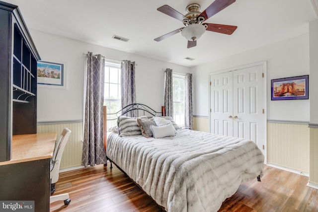 bedroom with a closet, ceiling fan, and dark hardwood / wood-style floors