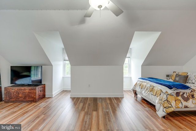 bedroom with multiple windows, wood-type flooring, lofted ceiling, and ceiling fan