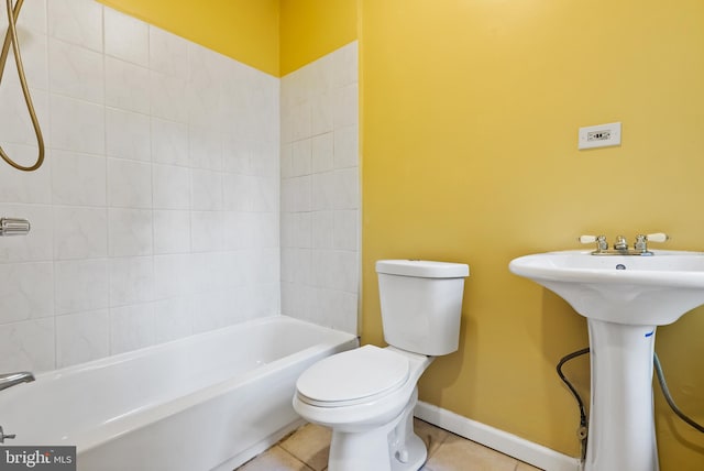 full bathroom featuring tiled shower / bath, sink, toilet, and tile patterned floors