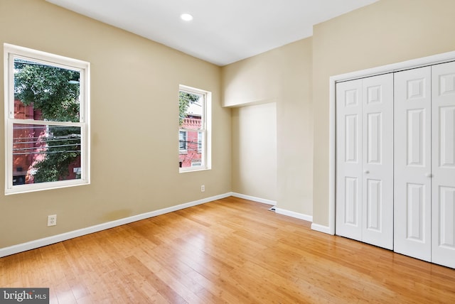 unfurnished bedroom with hardwood / wood-style flooring and a closet