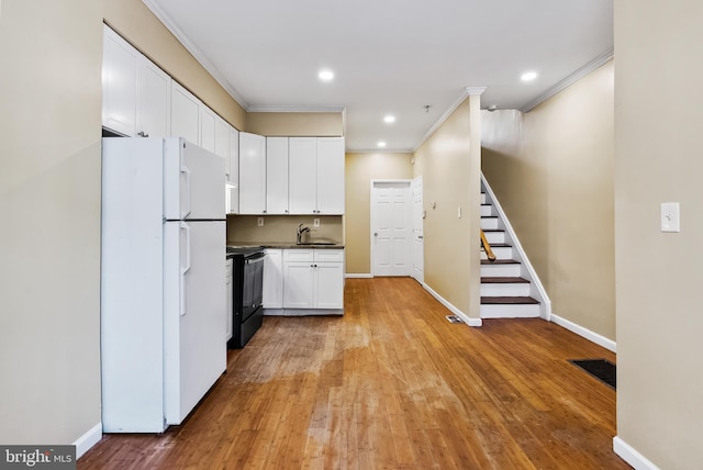 kitchen with white cabinetry, light hardwood / wood-style flooring, black range with electric stovetop, and white fridge