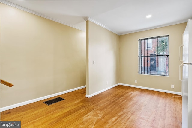 empty room with crown molding and hardwood / wood-style flooring