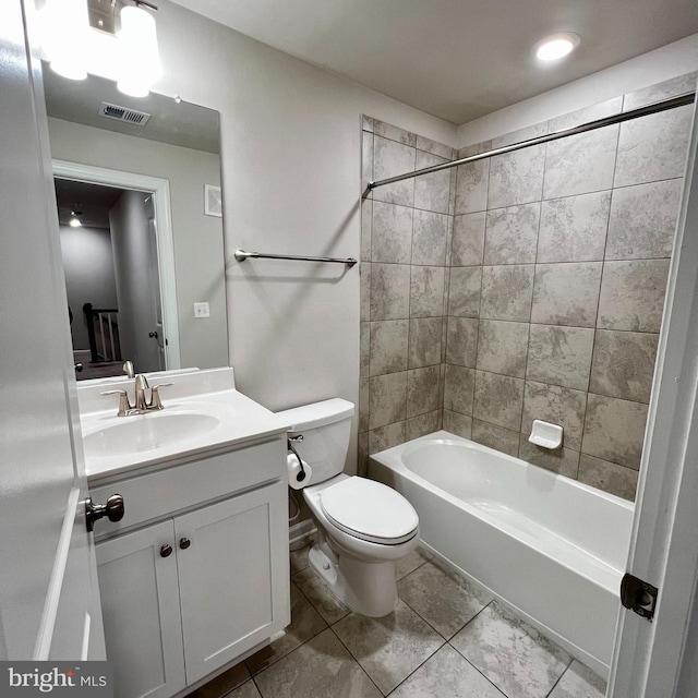 full bathroom with tiled shower / bath, vanity, toilet, and tile patterned floors