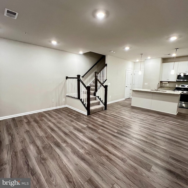 unfurnished living room with sink and dark wood-type flooring