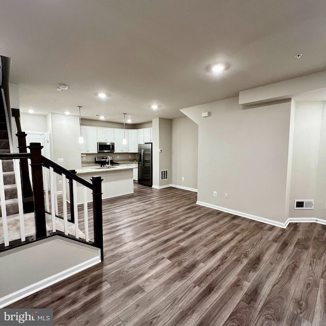 unfurnished living room with sink and dark wood-type flooring