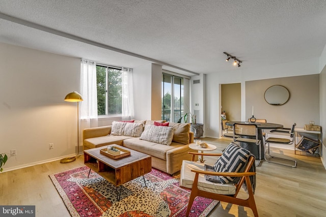 living room featuring a textured ceiling and light hardwood / wood-style flooring