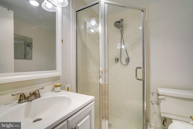 bathroom featuring vanity, toilet, and an enclosed shower