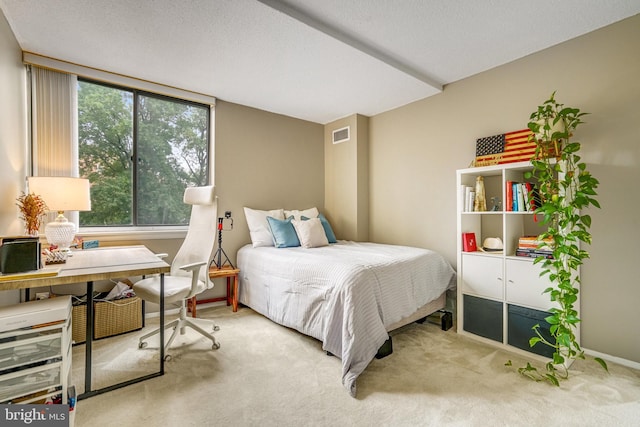 bedroom with light carpet and a textured ceiling