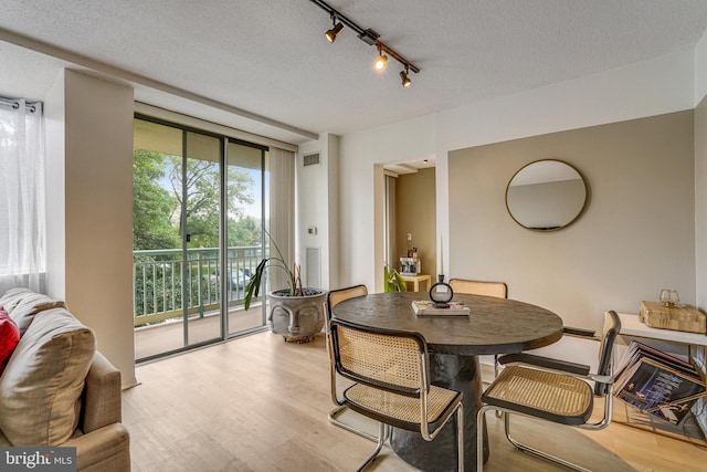 dining area featuring a textured ceiling and light wood-type flooring