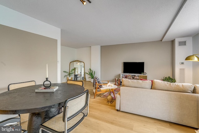 dining room featuring a textured ceiling and light hardwood / wood-style flooring