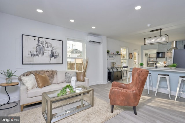 living room featuring light hardwood / wood-style floors and a wall unit AC