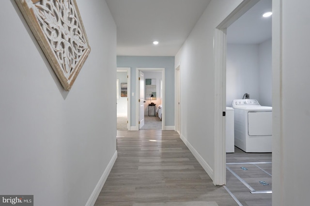 corridor with washer / dryer and light hardwood / wood-style floors