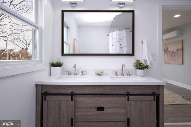 bathroom with an AC wall unit, hardwood / wood-style floors, and vanity