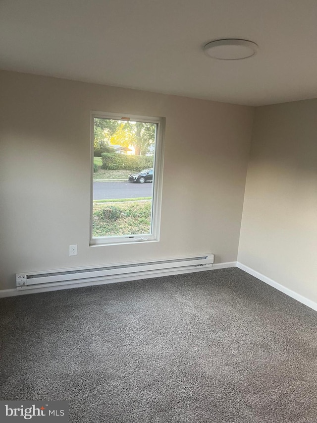 unfurnished room featuring a baseboard heating unit and carpet floors