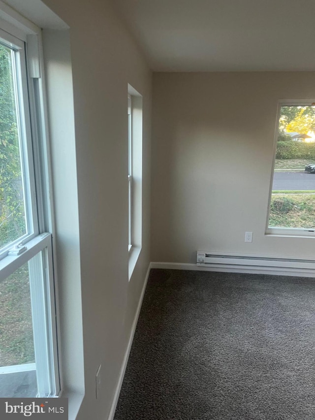 carpeted spare room featuring a baseboard radiator