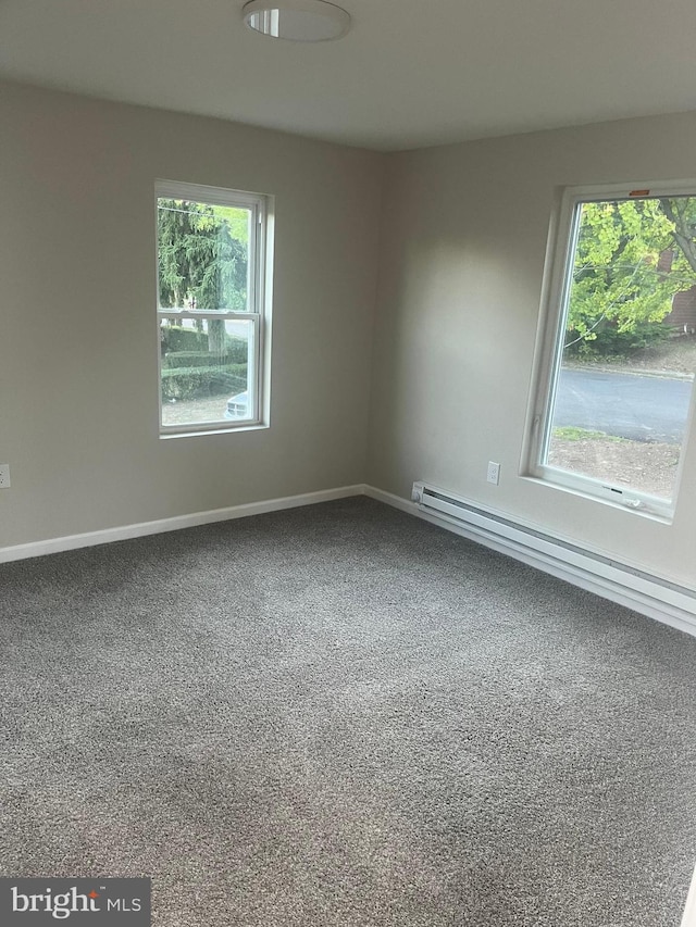 unfurnished room with a baseboard radiator, plenty of natural light, and carpet floors