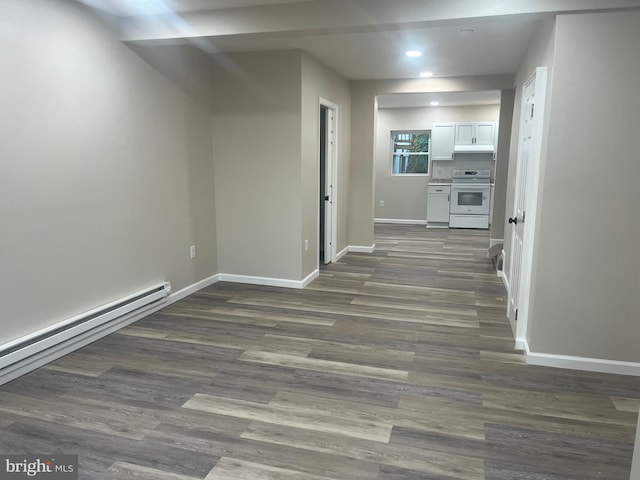 hallway with baseboard heating and dark hardwood / wood-style flooring