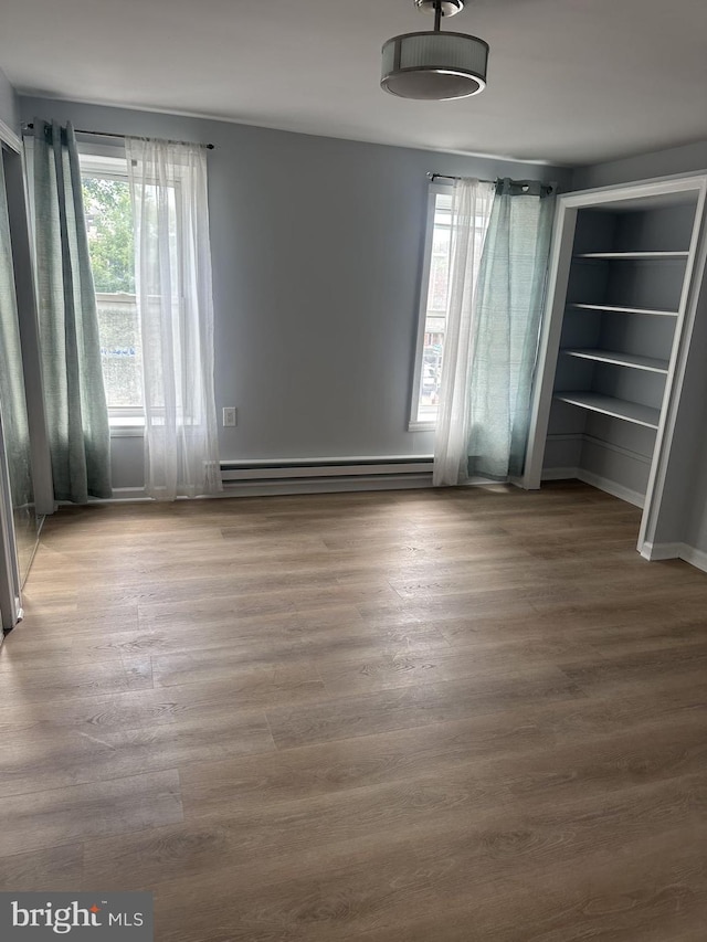 interior space featuring a baseboard heating unit and wood-type flooring