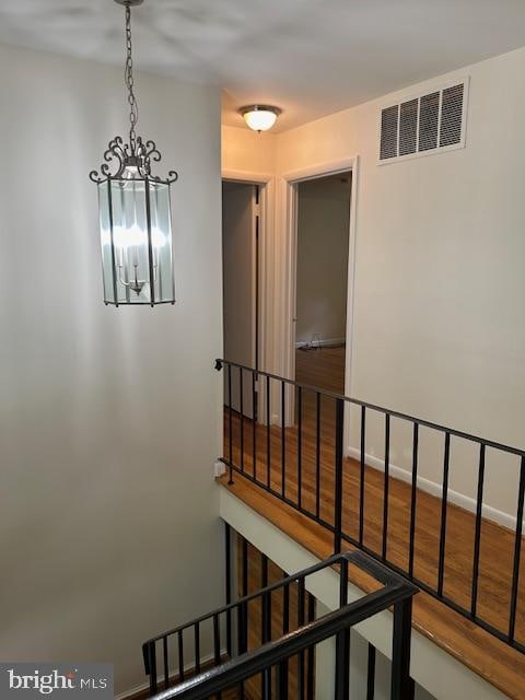 hallway featuring hardwood / wood-style floors and a chandelier