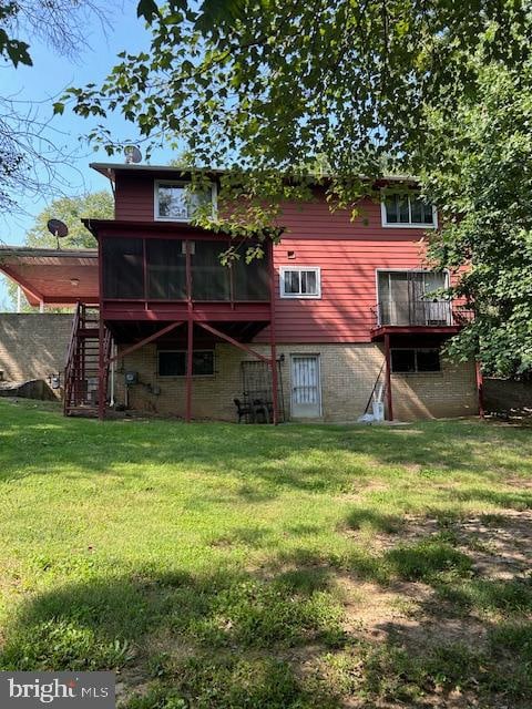 back of house featuring a wooden deck and a yard