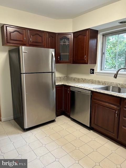 kitchen with dark brown cabinetry, stainless steel appliances, and sink