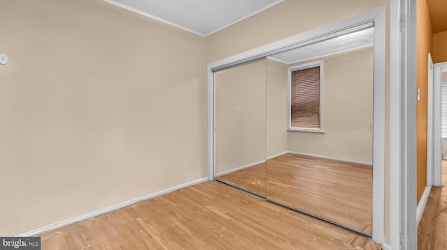 unfurnished bedroom with hardwood / wood-style flooring and a closet