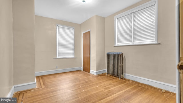 empty room featuring light hardwood / wood-style flooring and radiator heating unit