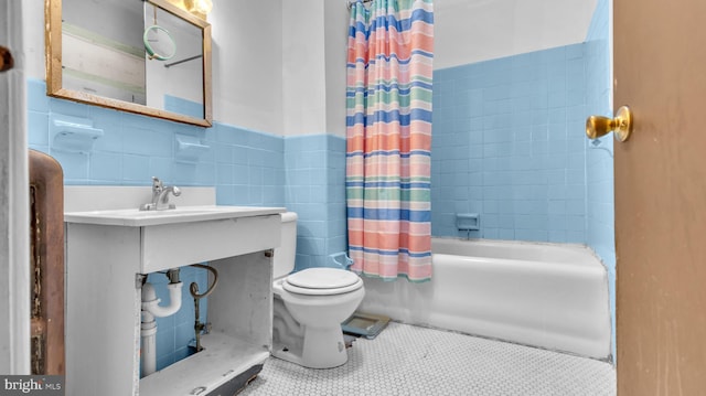 full bathroom with shower / bath combination with curtain, tile walls, tile patterned floors, vanity, and toilet