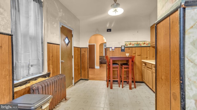 kitchen featuring radiator and wood walls