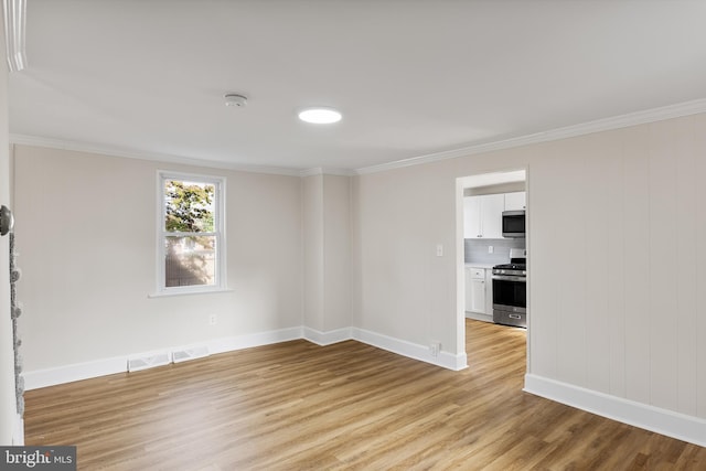 empty room featuring crown molding and light hardwood / wood-style flooring