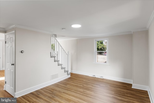 spare room with wood-type flooring and crown molding