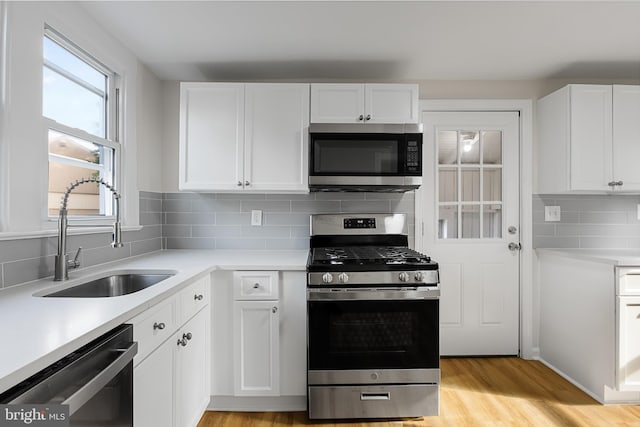 kitchen featuring light wood-type flooring, white cabinetry, sink, and stainless steel appliances