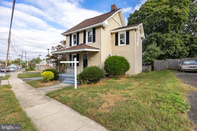 front facade with a front lawn and covered porch