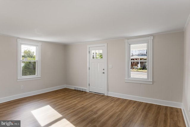 entryway featuring hardwood / wood-style flooring, crown molding, and a healthy amount of sunlight