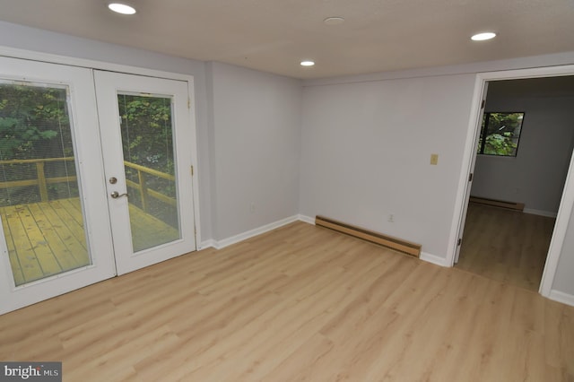 spare room featuring light hardwood / wood-style floors, french doors, and baseboard heating