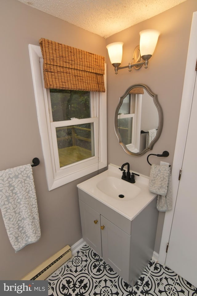 bathroom featuring vanity, a textured ceiling, and a baseboard heating unit