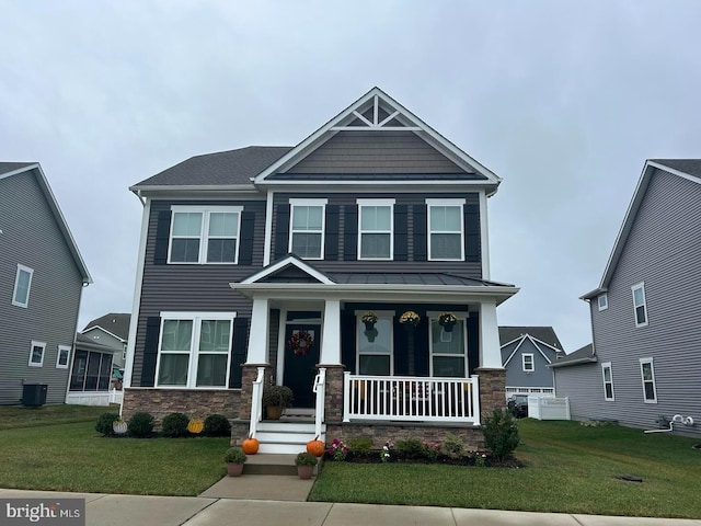 craftsman house with covered porch, a front yard, and central air condition unit