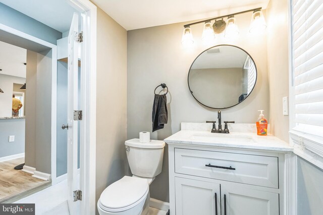 bathroom with vanity, hardwood / wood-style flooring, and toilet