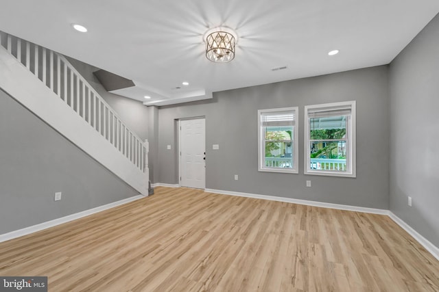 foyer featuring light wood-type flooring and a chandelier