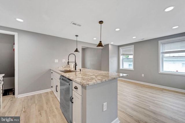 kitchen featuring light stone counters, sink, stainless steel dishwasher, decorative light fixtures, and white cabinetry