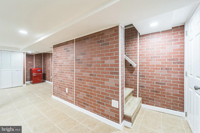 interior space with brick wall and tile patterned floors