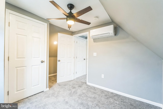 interior space featuring ceiling fan, a closet, light colored carpet, vaulted ceiling, and a wall unit AC