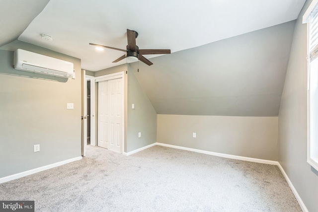 additional living space featuring vaulted ceiling, light carpet, ceiling fan, and a wall unit AC