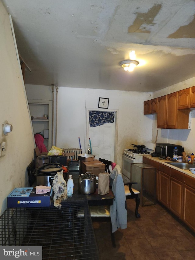 kitchen featuring white gas range oven and sink